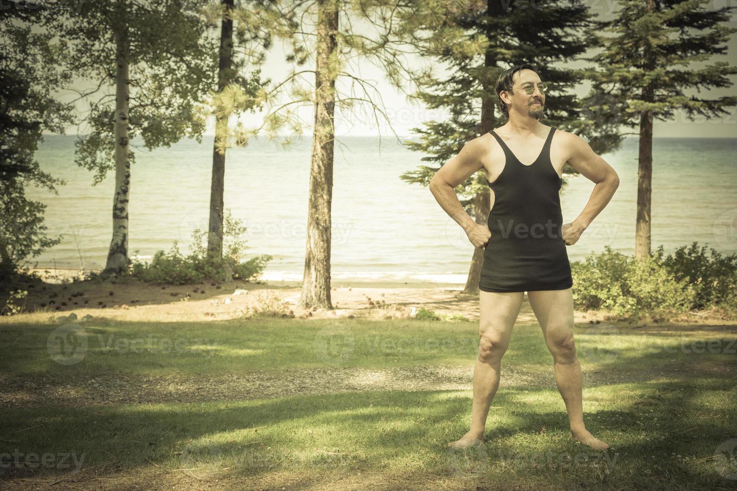 Gentleman Dressed in 1920's Era Swimsuit Holding Suitcases on Porch photo