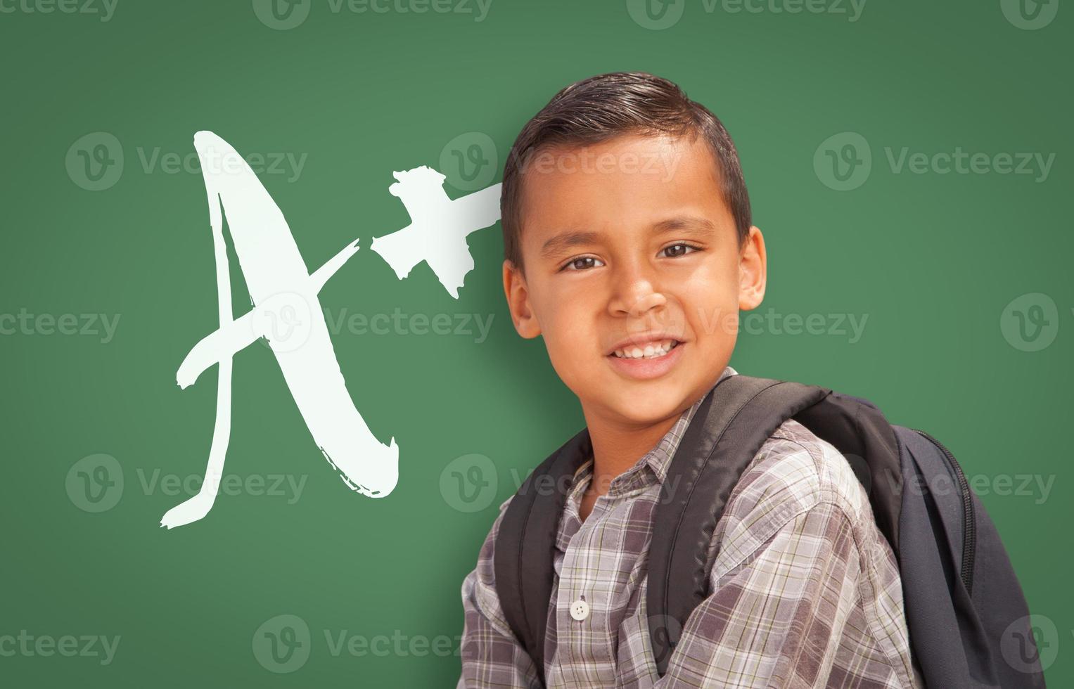Hispanic Boy Up in Front of A Written on Chalk Board photo