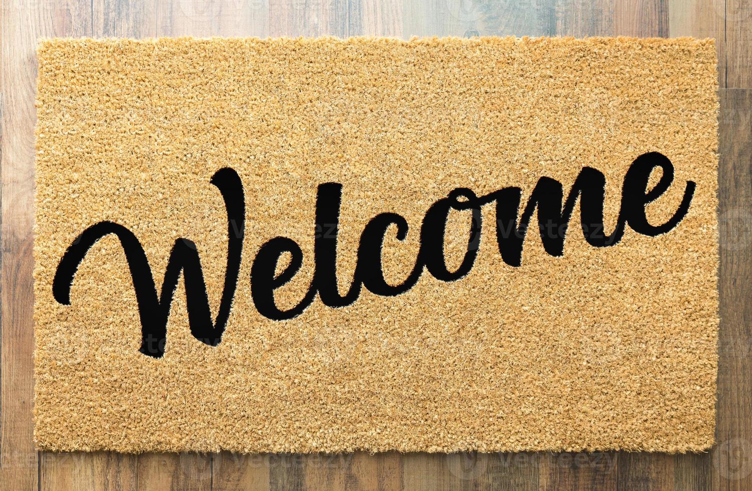 Tan Welcome Mat On Wood Floor Background. photo