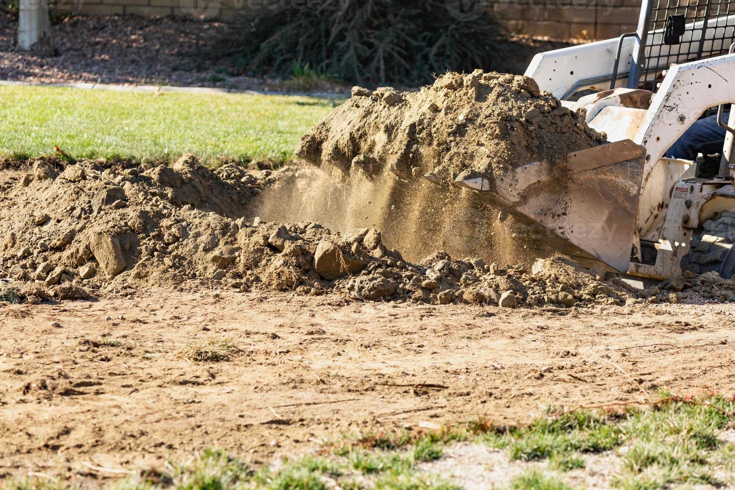 Small Bulldozer Digging In Yard For Pool Installation photo