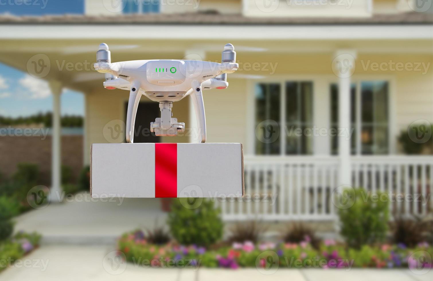 Unmanned Aircraft System UAV Quadcopter Drone Delivering Box With Red Ribbon To Home photo
