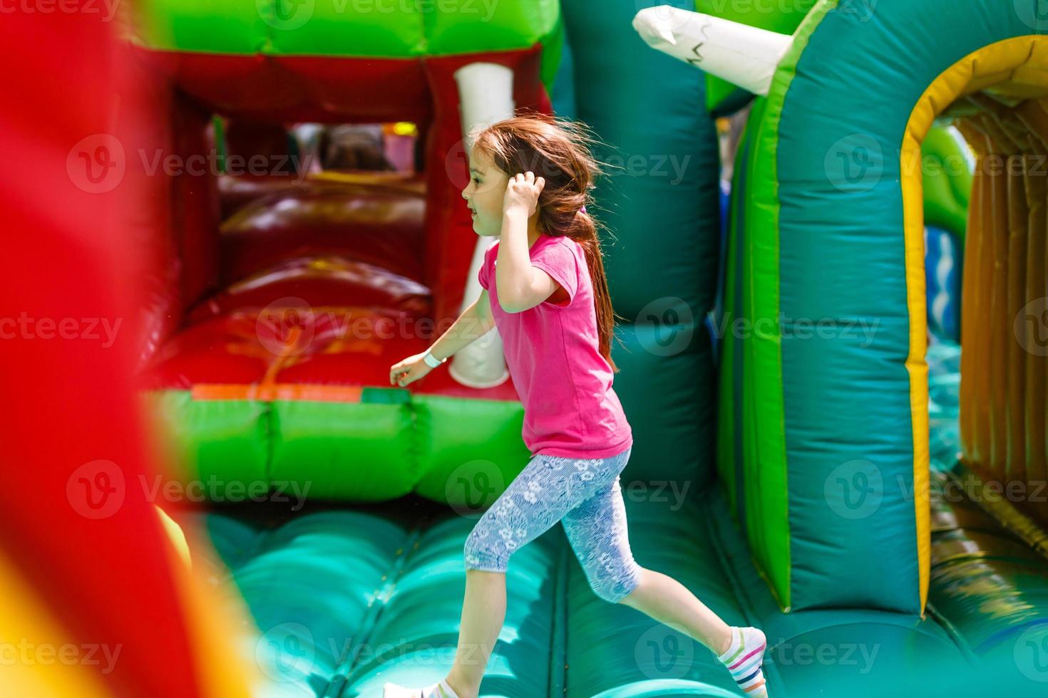 A cheerful child plays in an inflatable castle photo