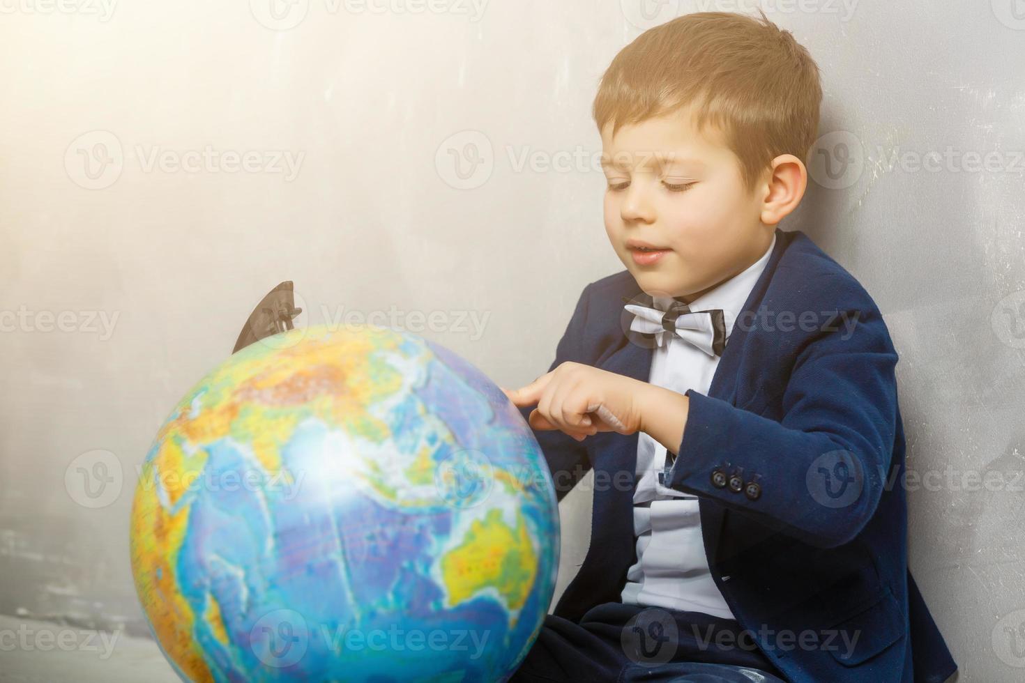 feliz niño curioso niño pequeño genio sobre fondo gris foto