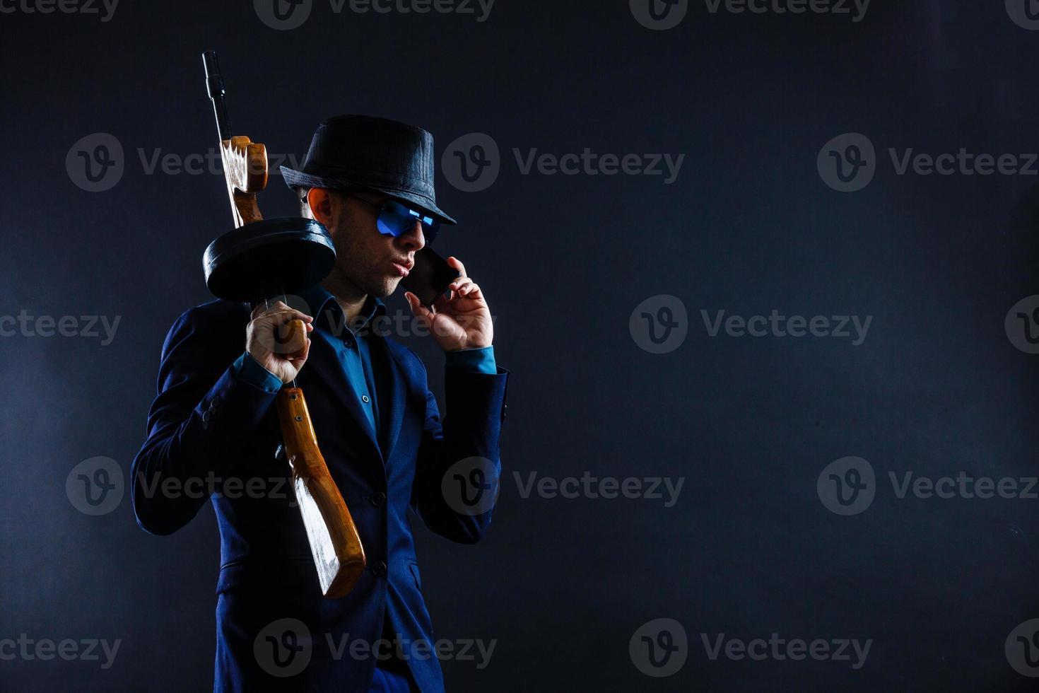 retrato de bajo perfil de un joven gángster con sombrero en la oscuridad foto