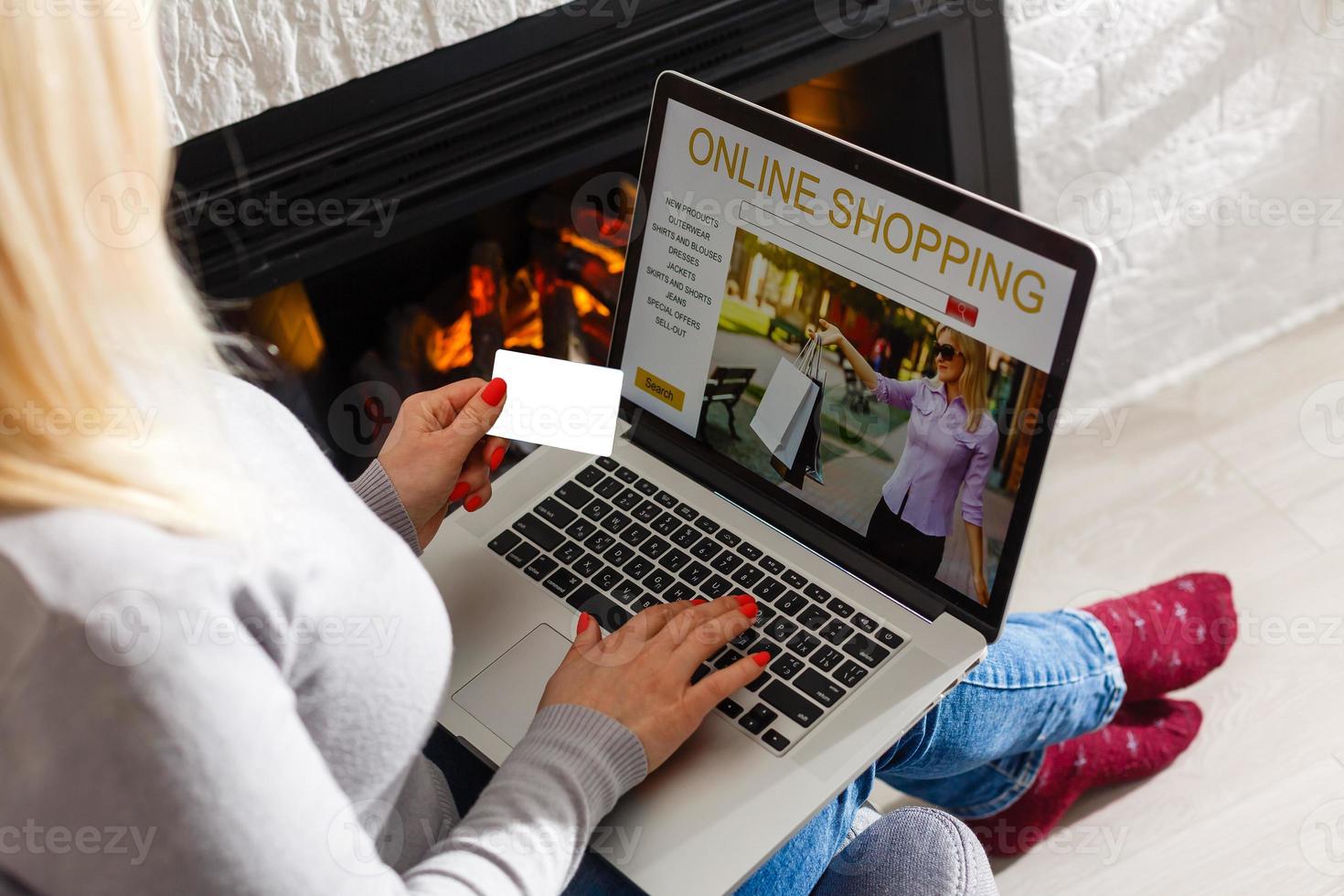 Online Shopping Concept. Back view of girl using laptop, looking at website, holding credit card, sitting at home photo