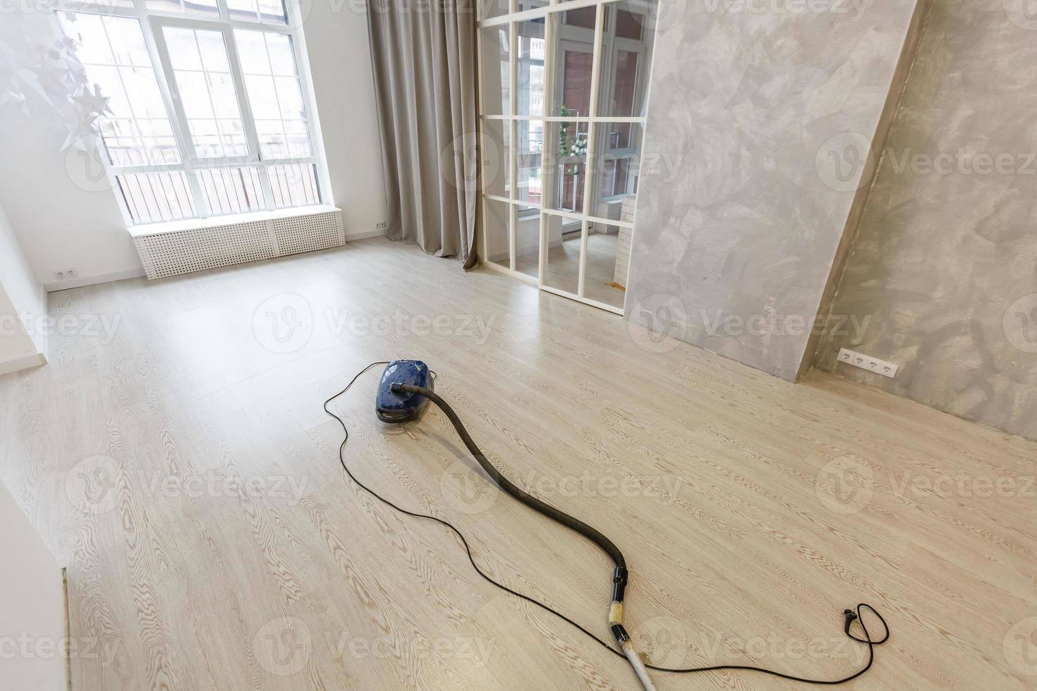 Cleaning of the apartment. Vacuum cleaner on the floor photo