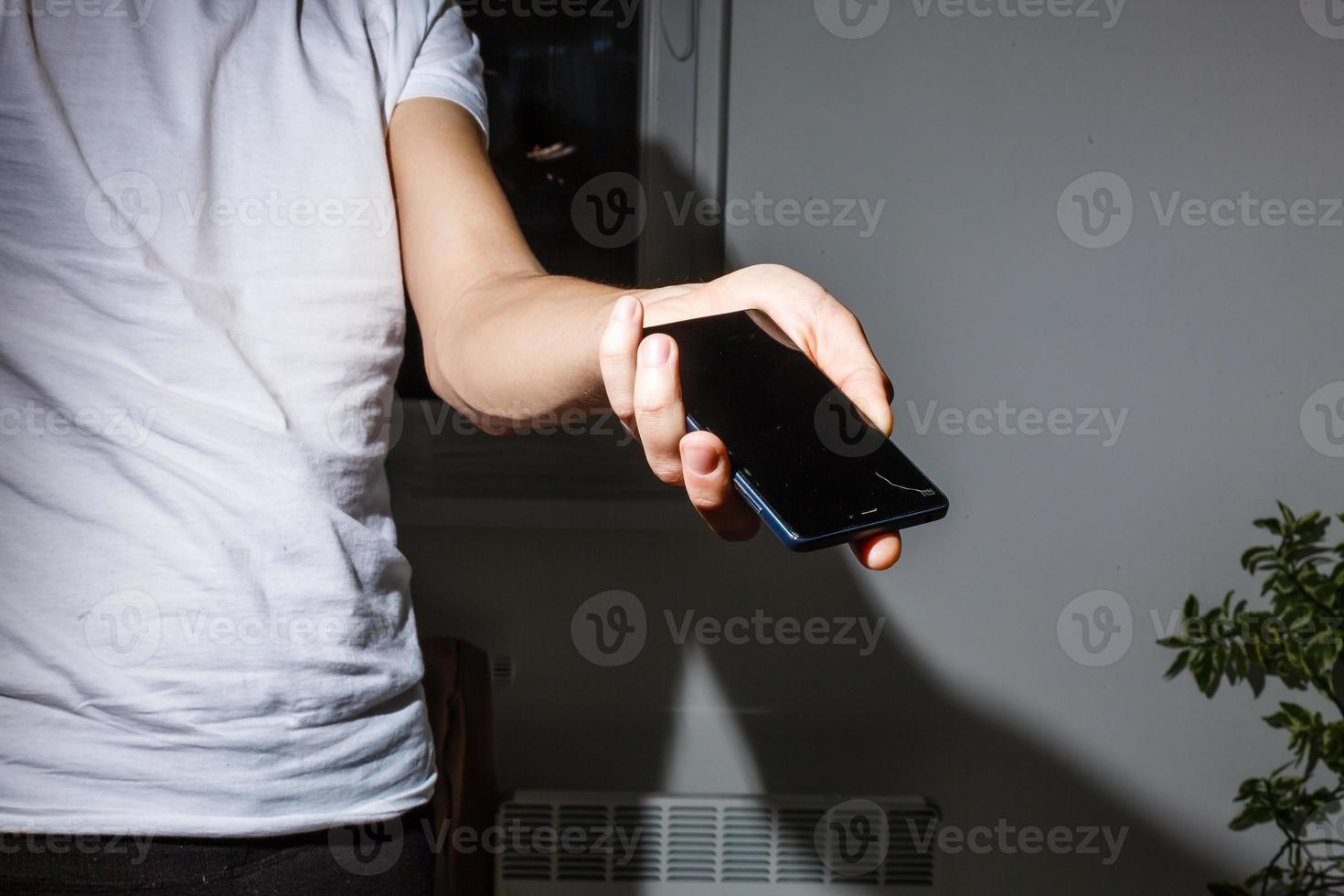 un hombre que sostiene un teléfono roto. foto