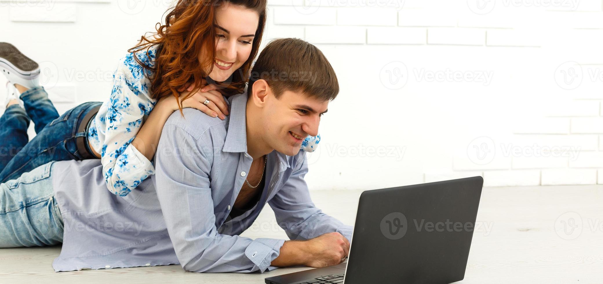 Couple buying online together with a laptop on a desktop at home photo