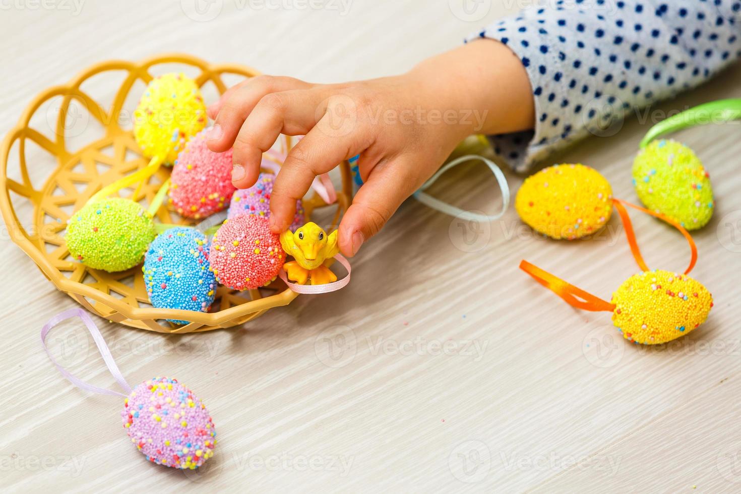 Cute smiling little girl with basket full of colorful easter eggs photo