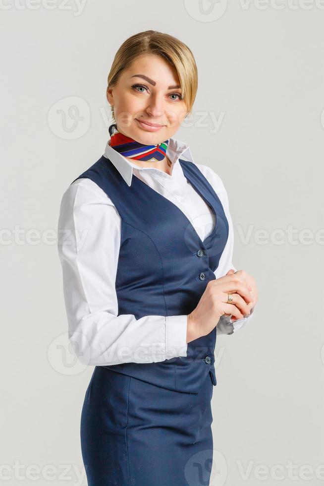 retrato de una encantadora azafata vestida con uniforme azul. aislado sobre fondo blanco foto