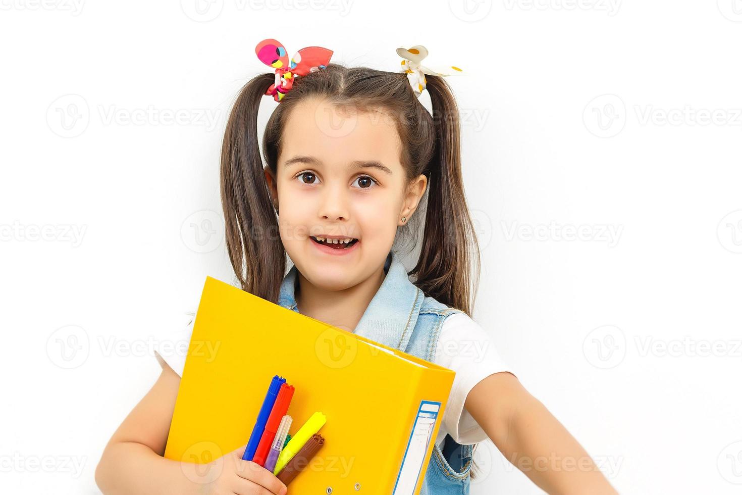 feliz y dulce colegiala que lleva mochila escolar y libros sonriendo en educación y concepto de regreso a la escuela aislado en fondo blanco foto