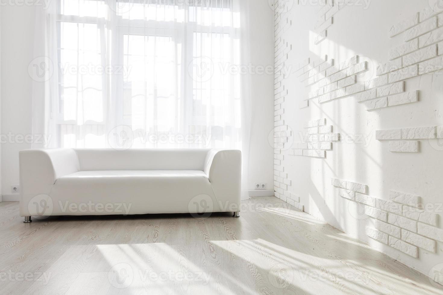interior luminoso y minimalista de la sala de estar con sofás blancos cerca de la ventana foto