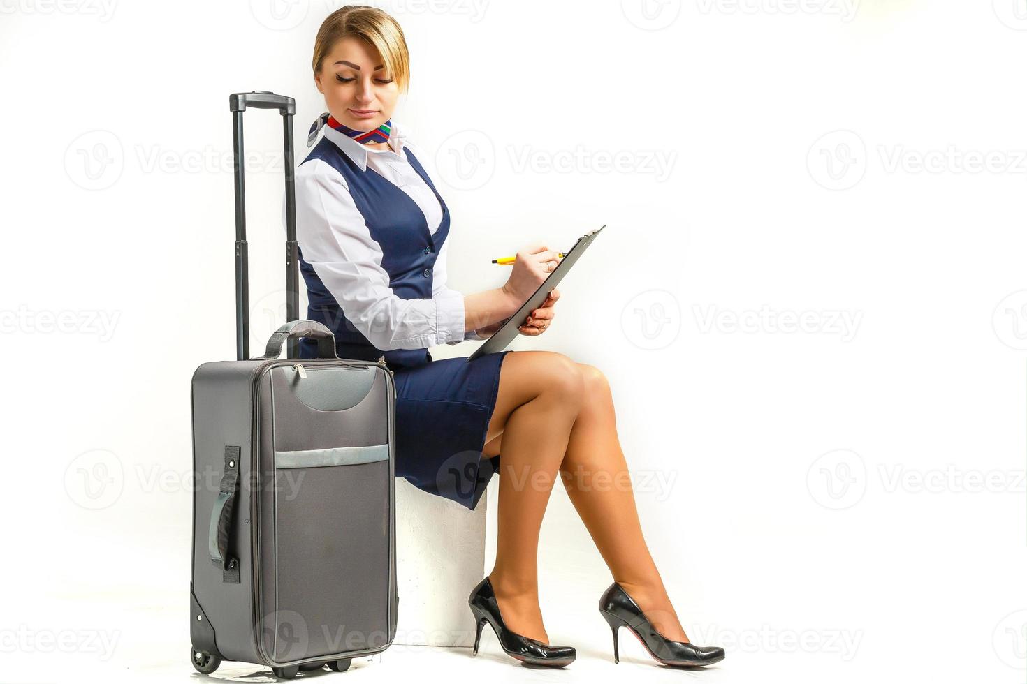 retrato de una encantadora azafata vestida con uniforme azul. aislado sobre fondo blanco. foto