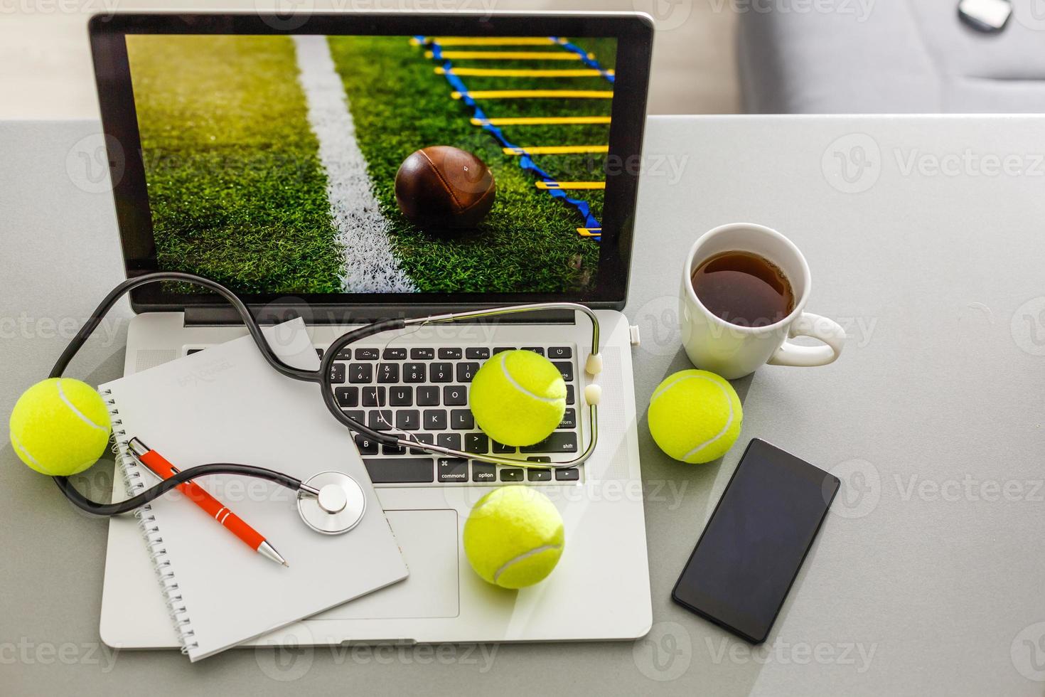 Sports tennis player with racket in blue costume. Woman atlete. Laptop on the table with design for bookmaker advertising photo