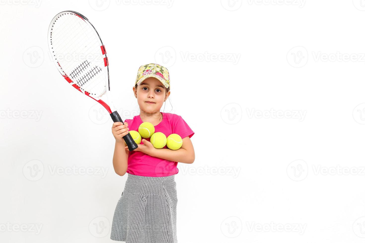 Cute little girl with tennis racket in her hands on white background photo