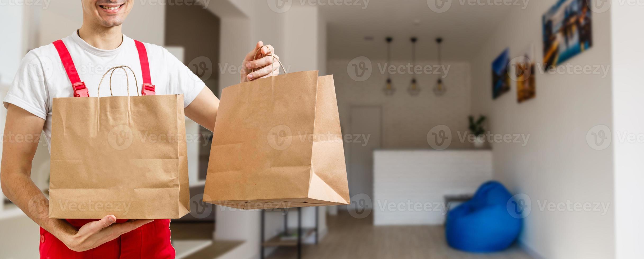Close up of delivery man carrying boxes in commercial kitchen photo