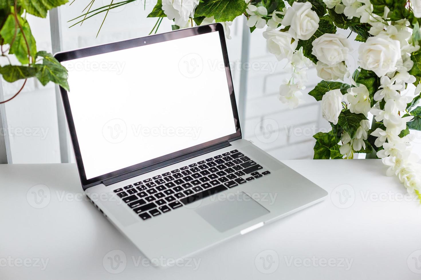 blank screen laptop, beautiful roses and eucalyptus bouquet, white vintage pastel background. Blog, website or social media concept photo