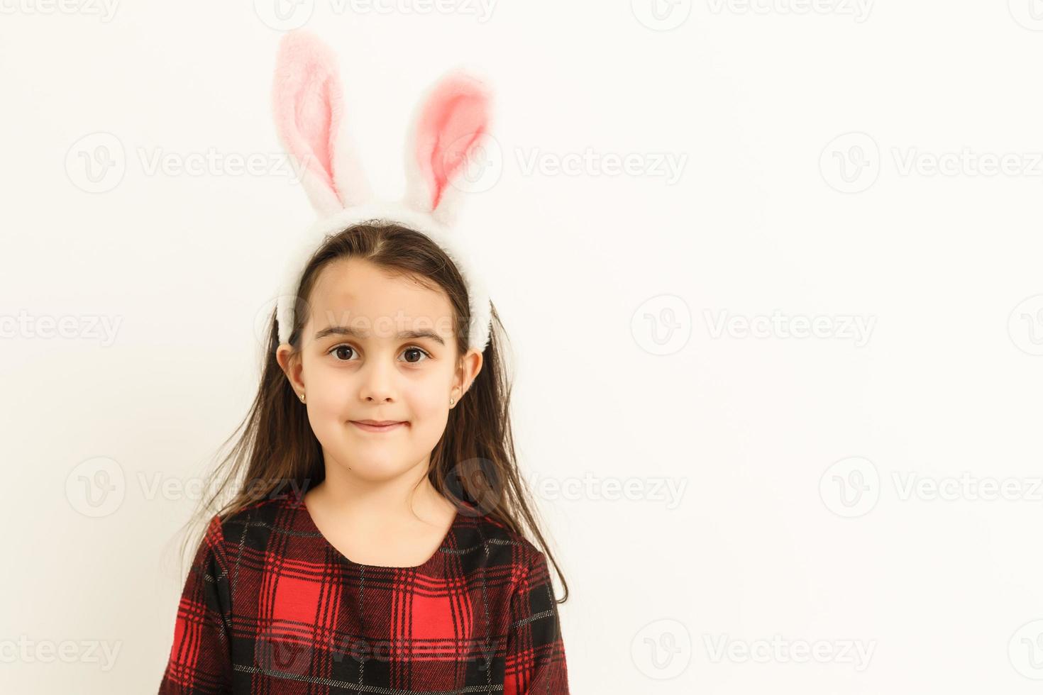 niña sorprendida con orejas de conejo, tendida sobre la luz en las vacaciones de pascua. foto