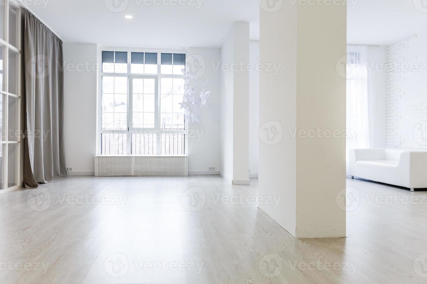 Empty waiting room with a modern gray sofa in front of the door and a clock on the wall photo