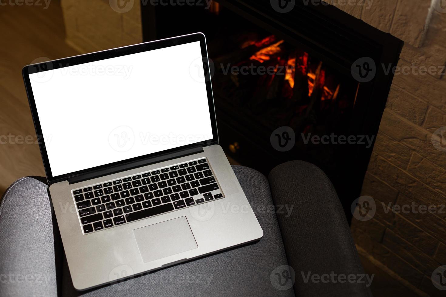 laptop and pile of books against the background of the fireplace photo