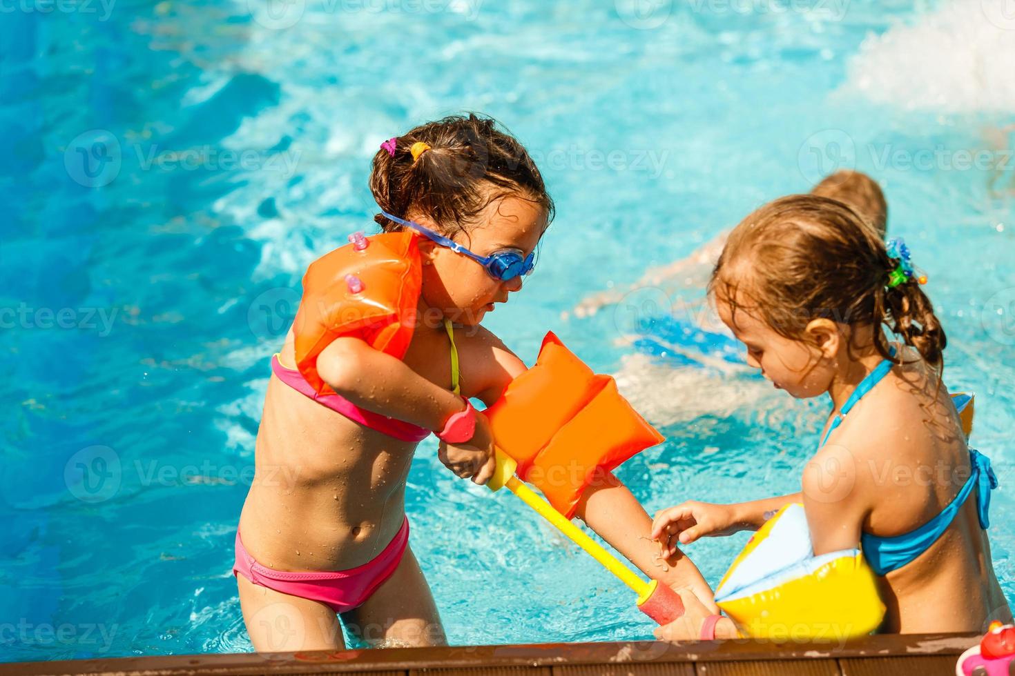 two little kids playing in the swimming pool photo