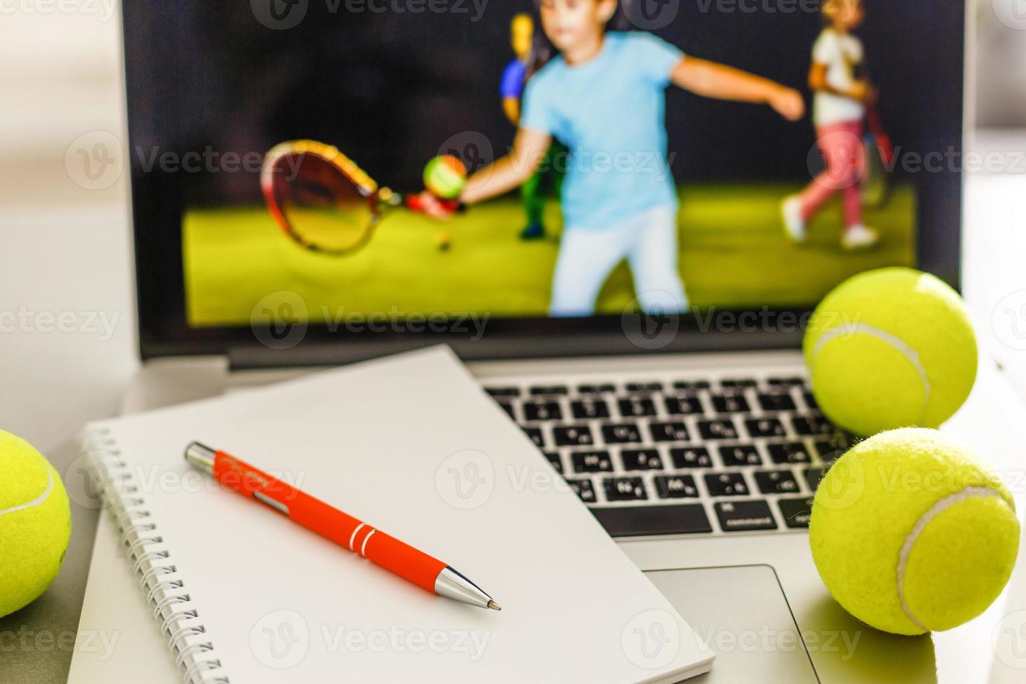 Sports tennis player with racket in blue costume. Woman atlete. Laptop on the table with design for bookmaker advertising photo