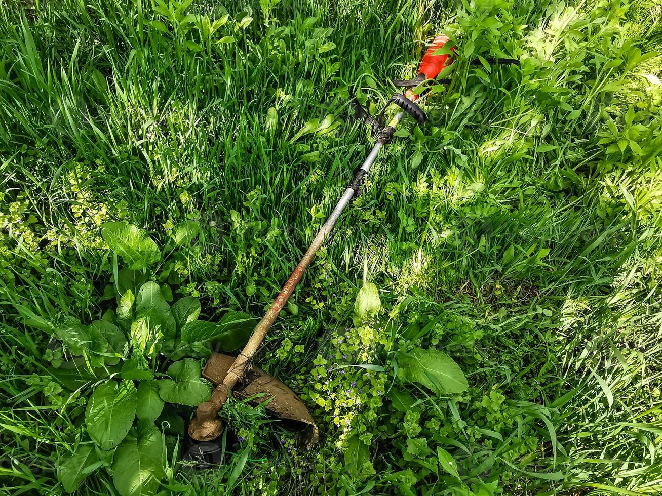 man with a manual lawn mower mows the grass photo