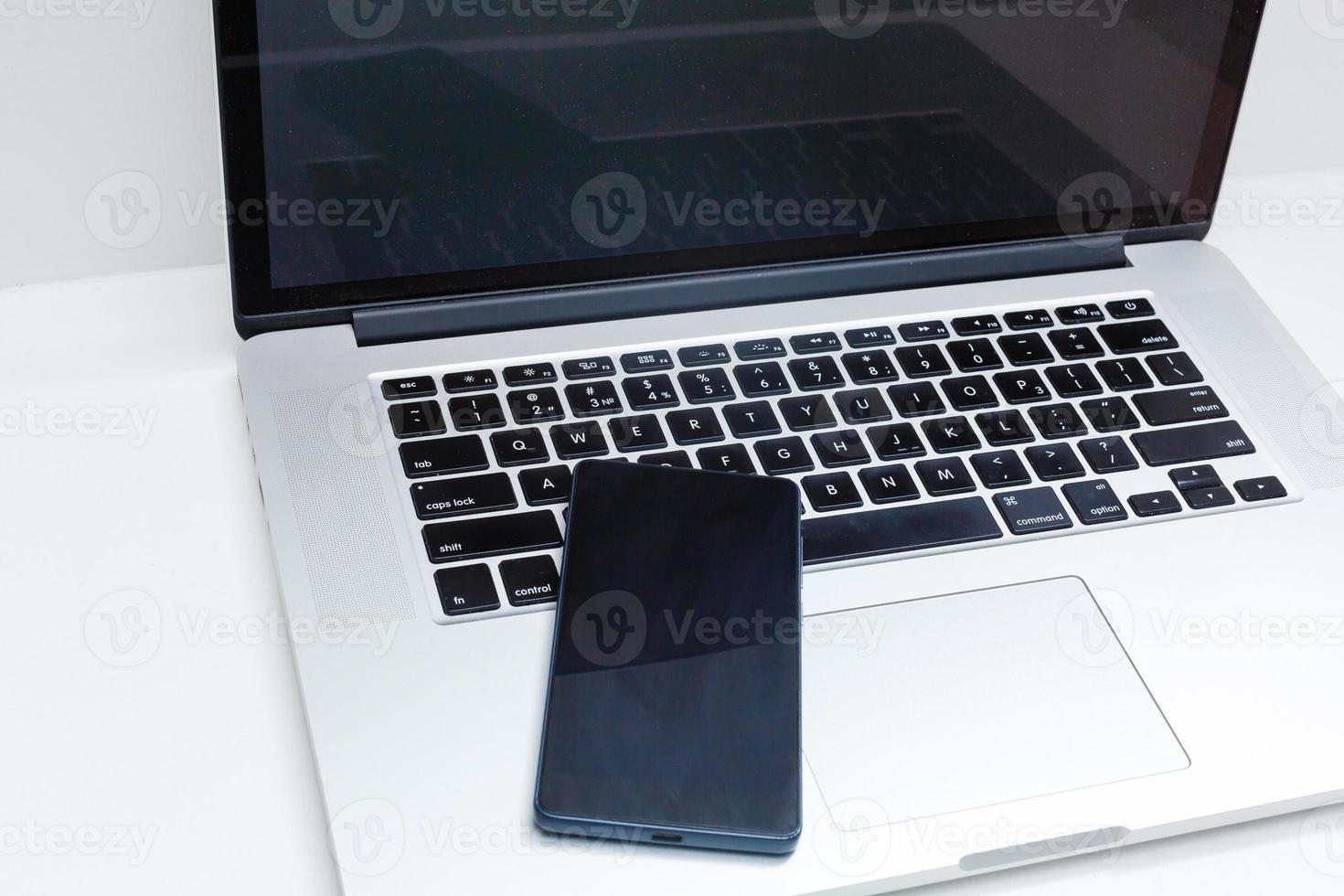 View of a Lapotop in high definition mobile on a wood background photo