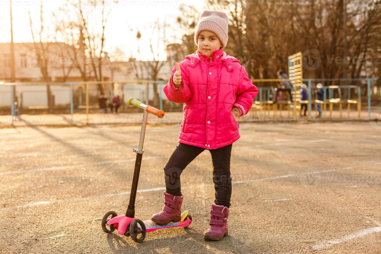 Child riding scooter. Kid on colorful kick board. Active outdoor fun for kids. Summer sports for preschool children. Little girl in spring park. photo