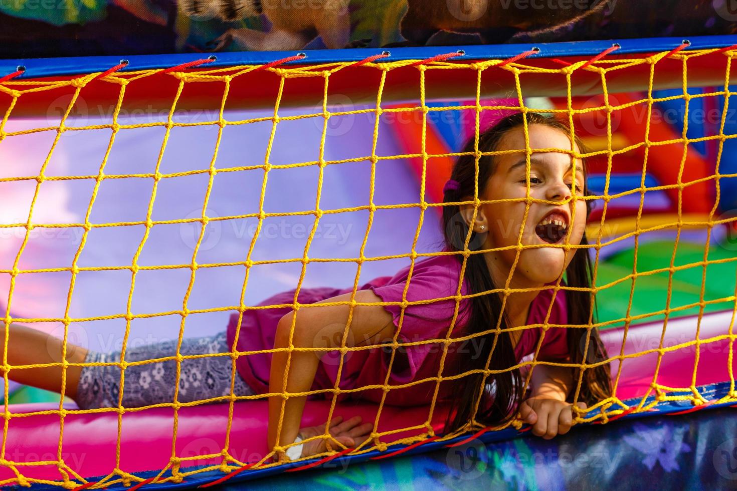 A cheerful child plays in an inflatable castle photo