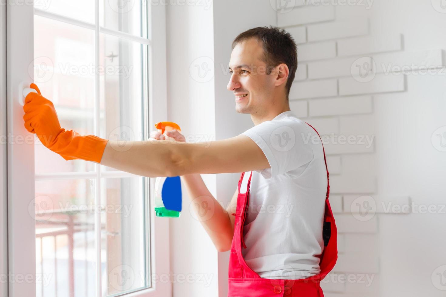 Young caucasians in uniforms working, clean up apartment, washing window photo