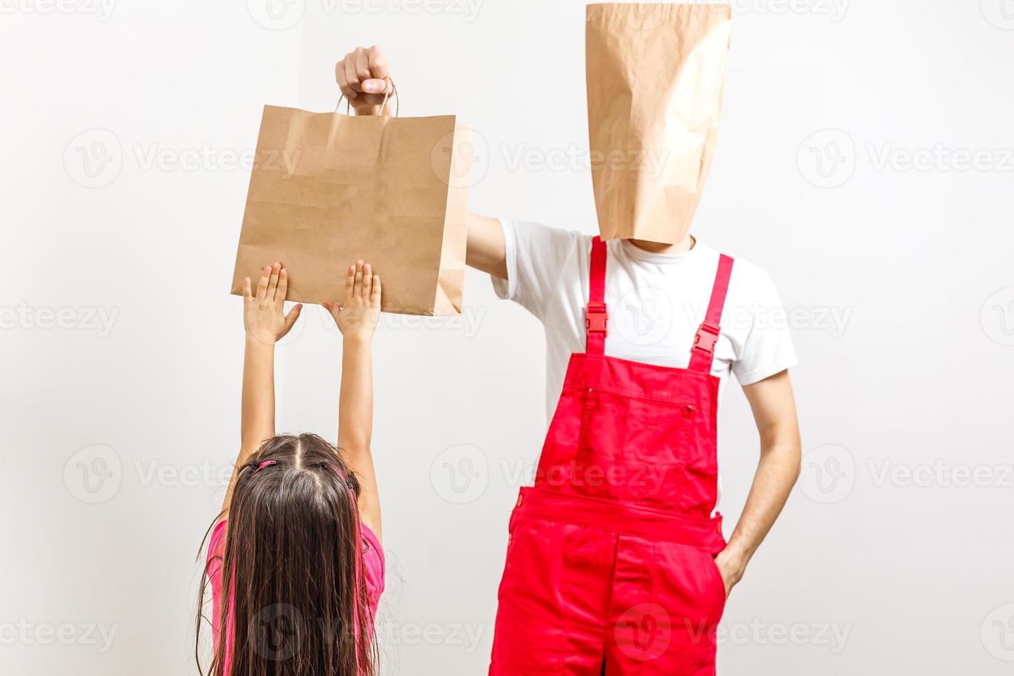 Delivery guy holding a paper bag and a clipboard isolated on white background photo