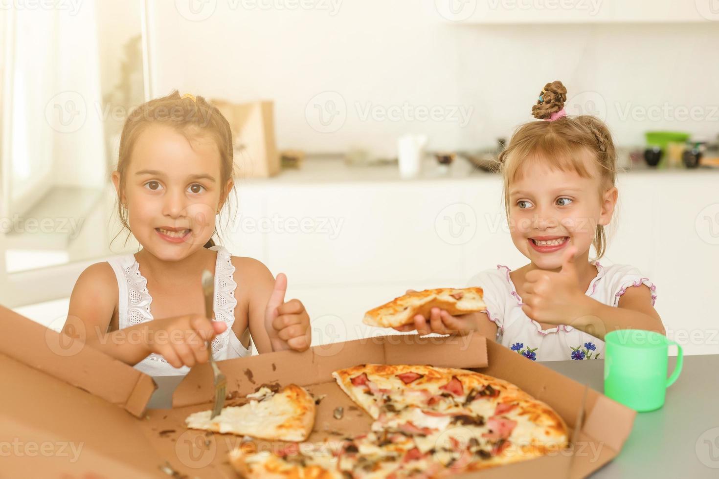 Two friends holding pizza - having fun eating dinner - Rebel concept - Focus on left slice photo