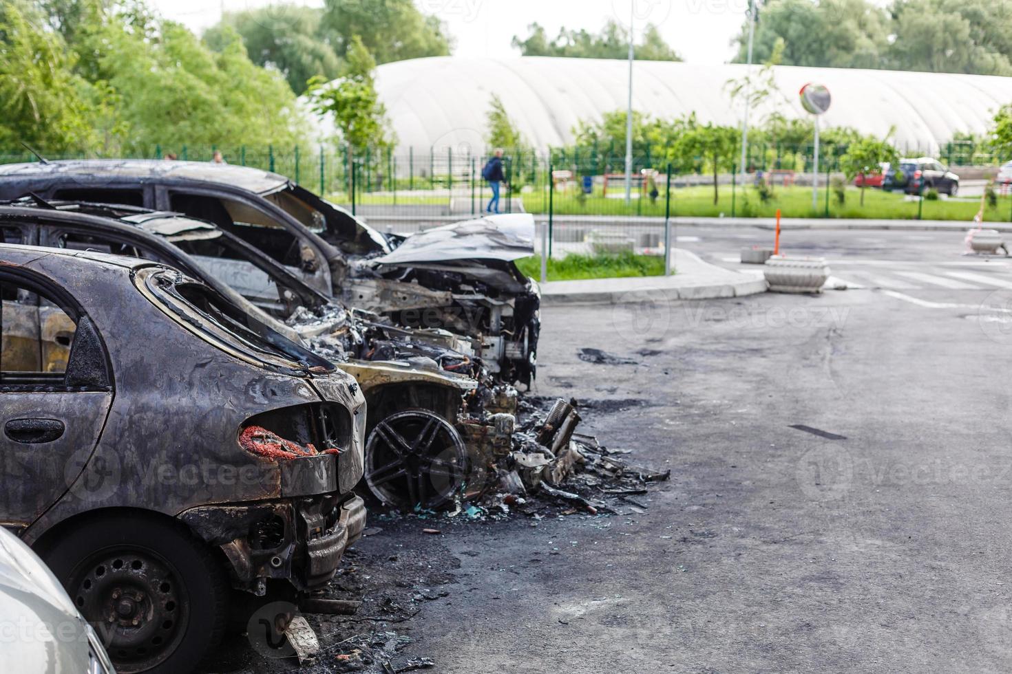 Two cars after the fire. Two burned out cars with an open hood. Arson, burnt car photo