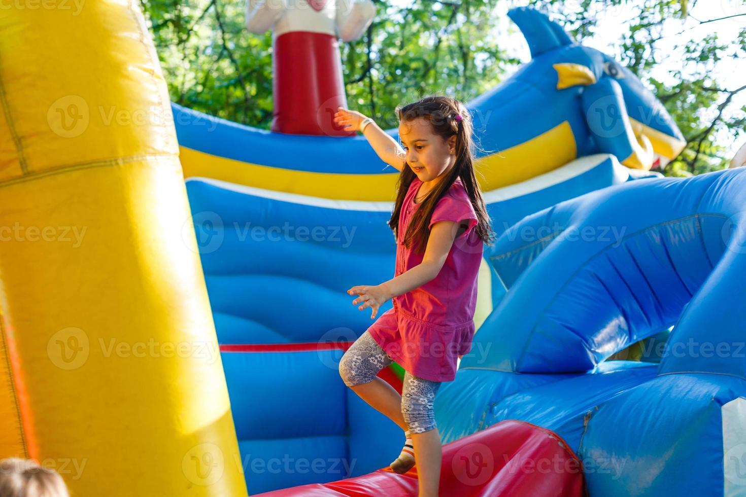 A cheerful child plays in an inflatable castle photo