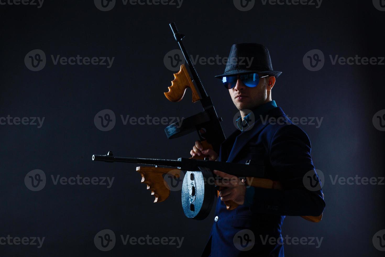 retrato de bajo perfil de un joven gángster con sombrero en la oscuridad foto