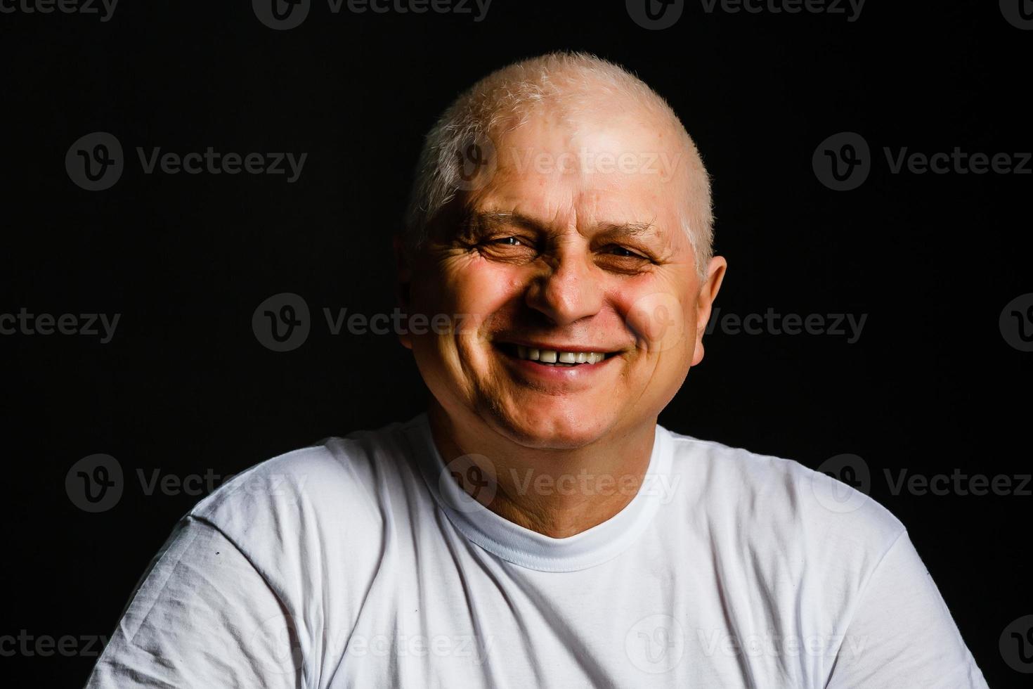 Portrait of an elderly man on black background photo