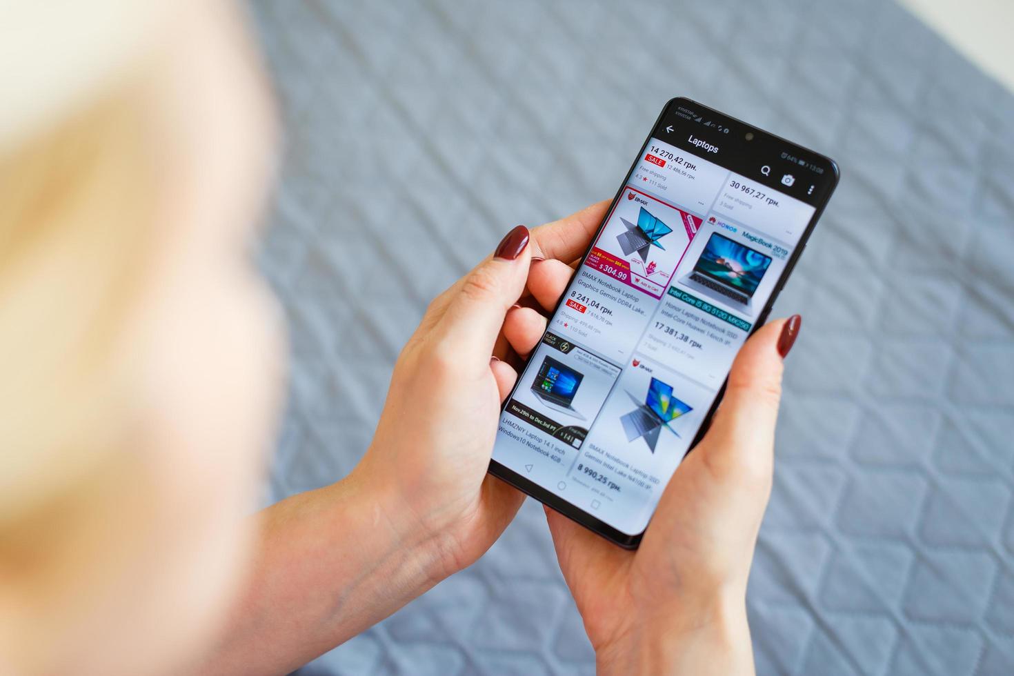 Kyiv, Ukraine - November 26, 2019 woman holding phone with Internet shopping service Aliexpress on the screen. photo