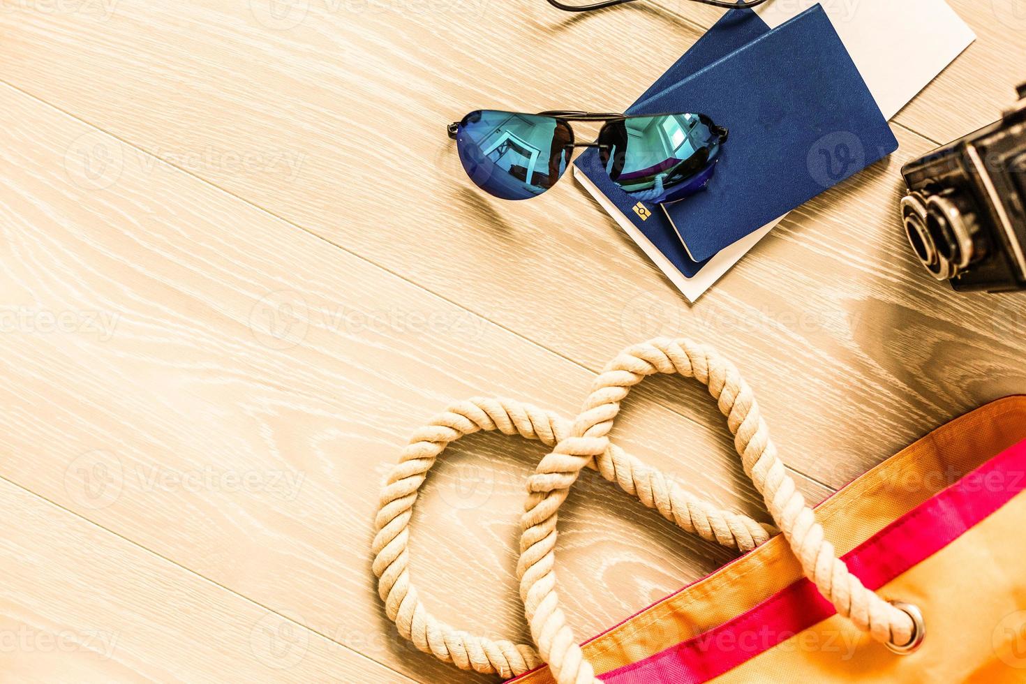 Flat lay traveler accessories on yellow background with palm leaf, camera and sunglasses. Top view travel or vacation concept. Summer background photo