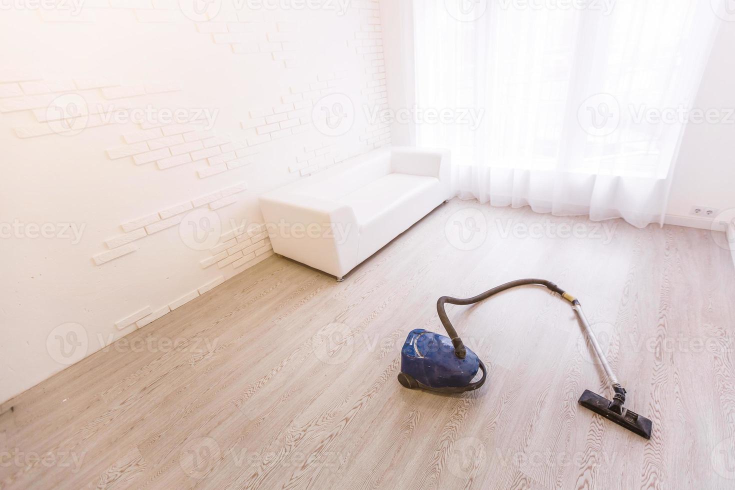 Vacuum cleaner on white concrete background in the house. photo