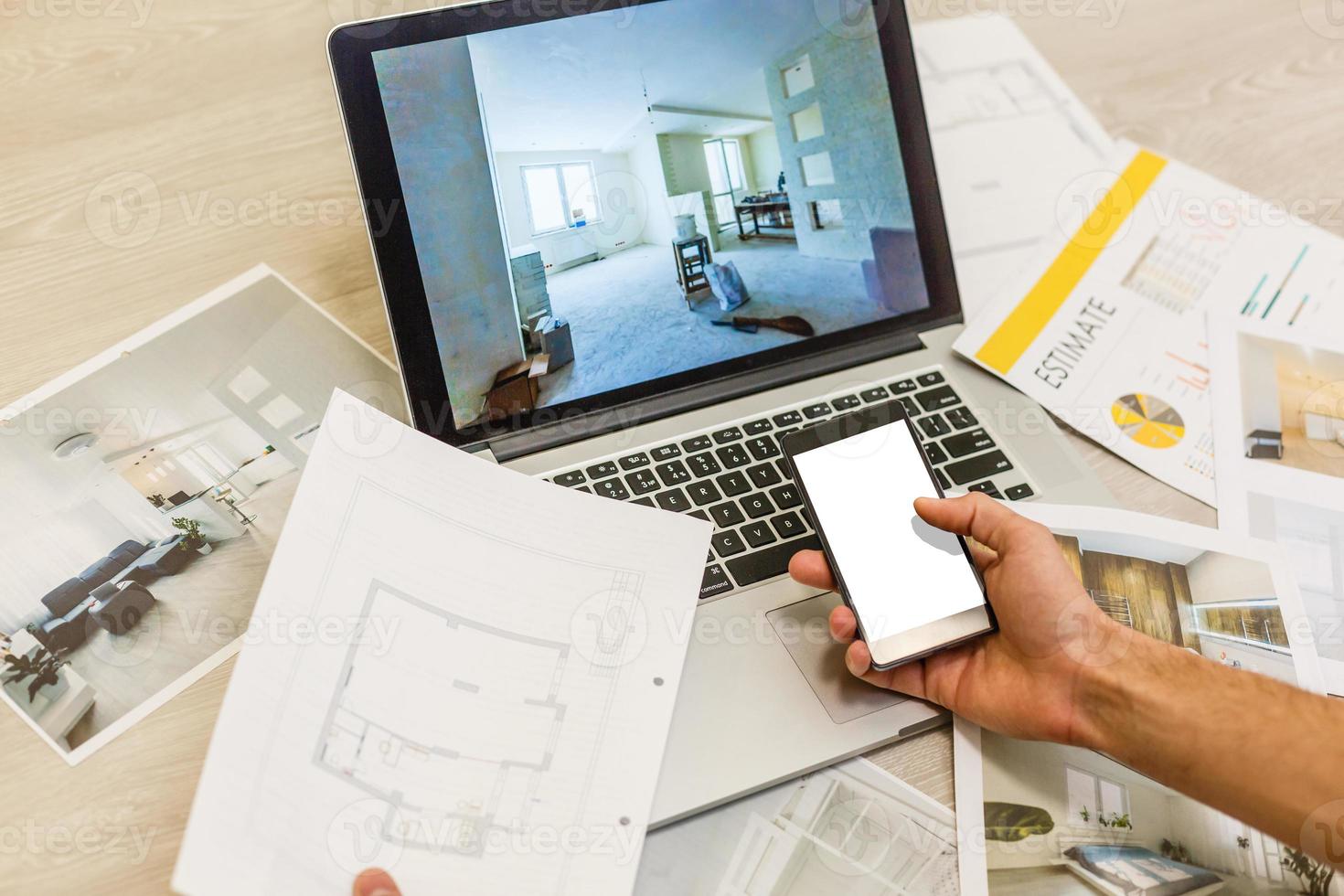 Construction engineer and architect's desk with house projects, laptop, tools and wood swatches top view, male hands drawing photo
