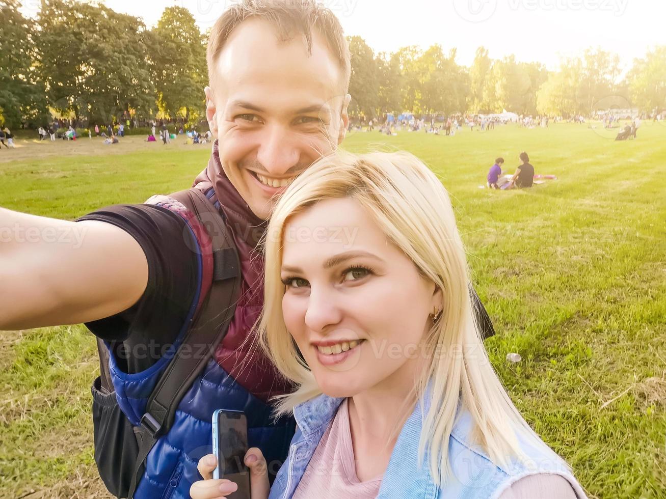 primer plano de una pareja joven toma selfie al aire libre. joven tomando una foto con su novia. feliz pareja sonriente tomando un selfie en un día de verano