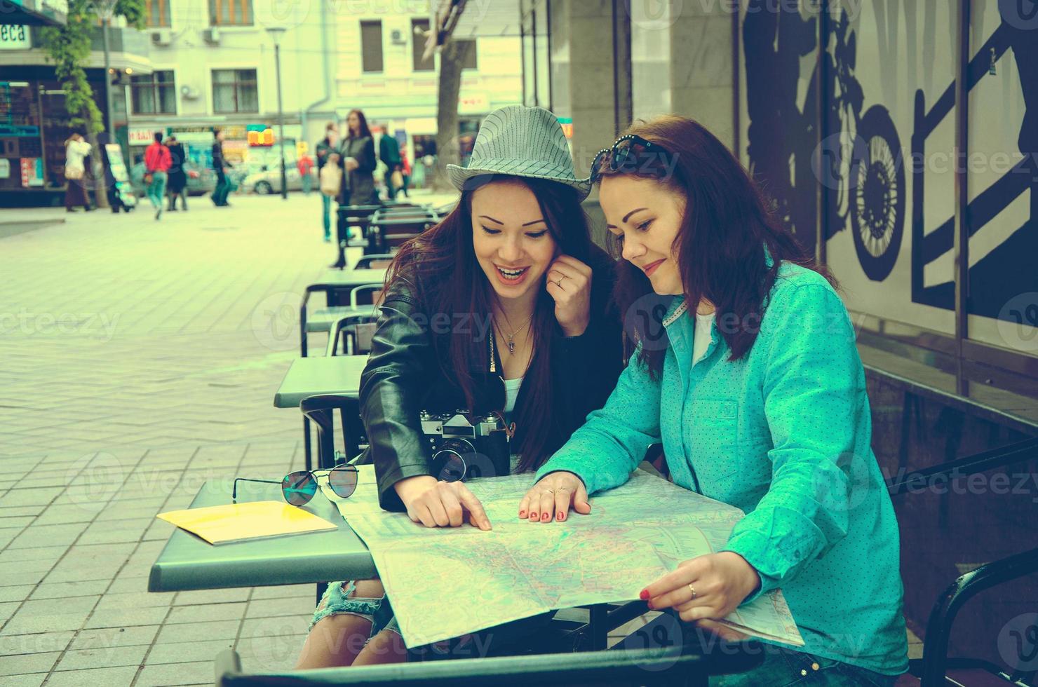 two women sitting at a table on the street photo