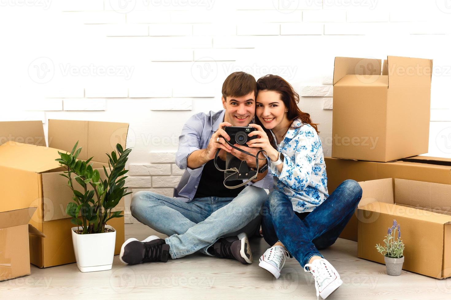 Smiling couple leaning on boxes in new home photo
