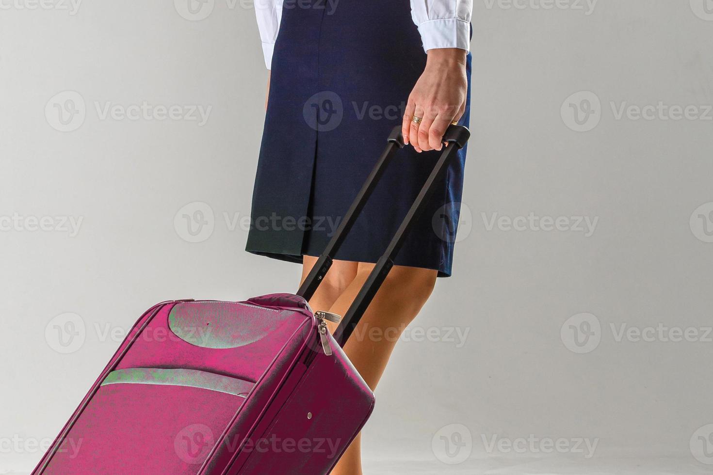 The stewardess goes and rolls her suitcase photo