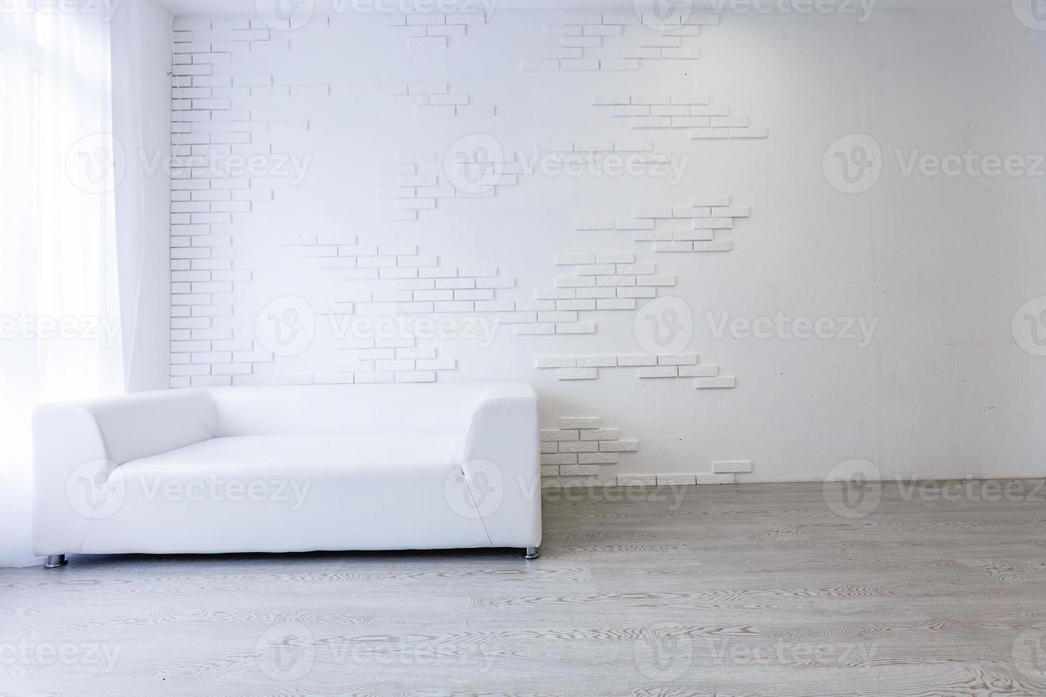 Empty waiting room with a modern gray sofa in front of the door and a clock on the wall photo