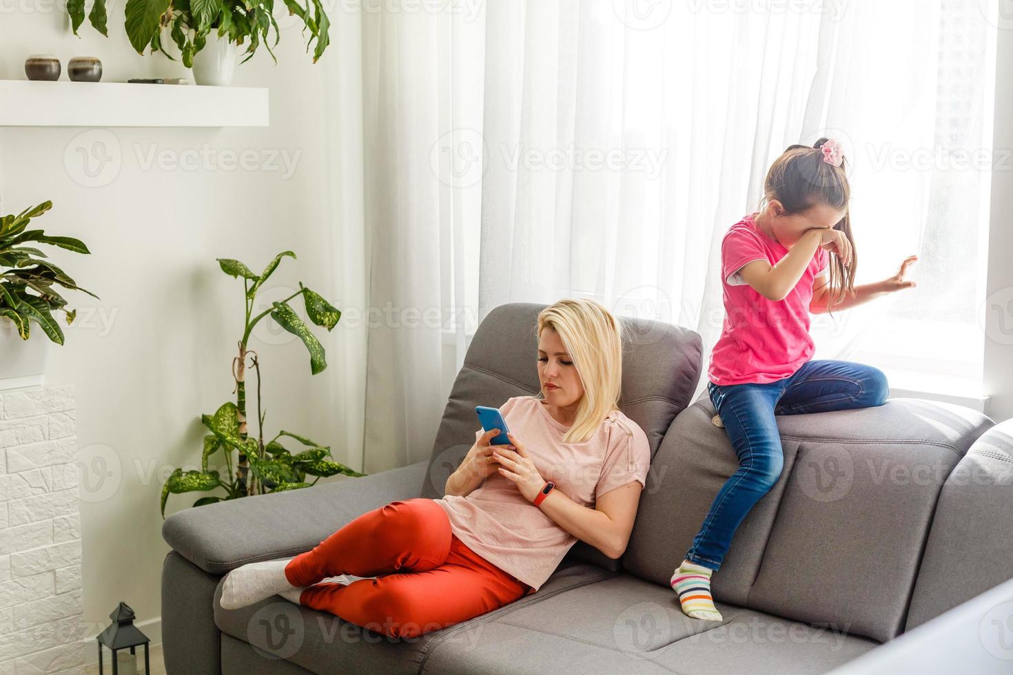 Mother comforting her teenage daughter at home on the couch photo
