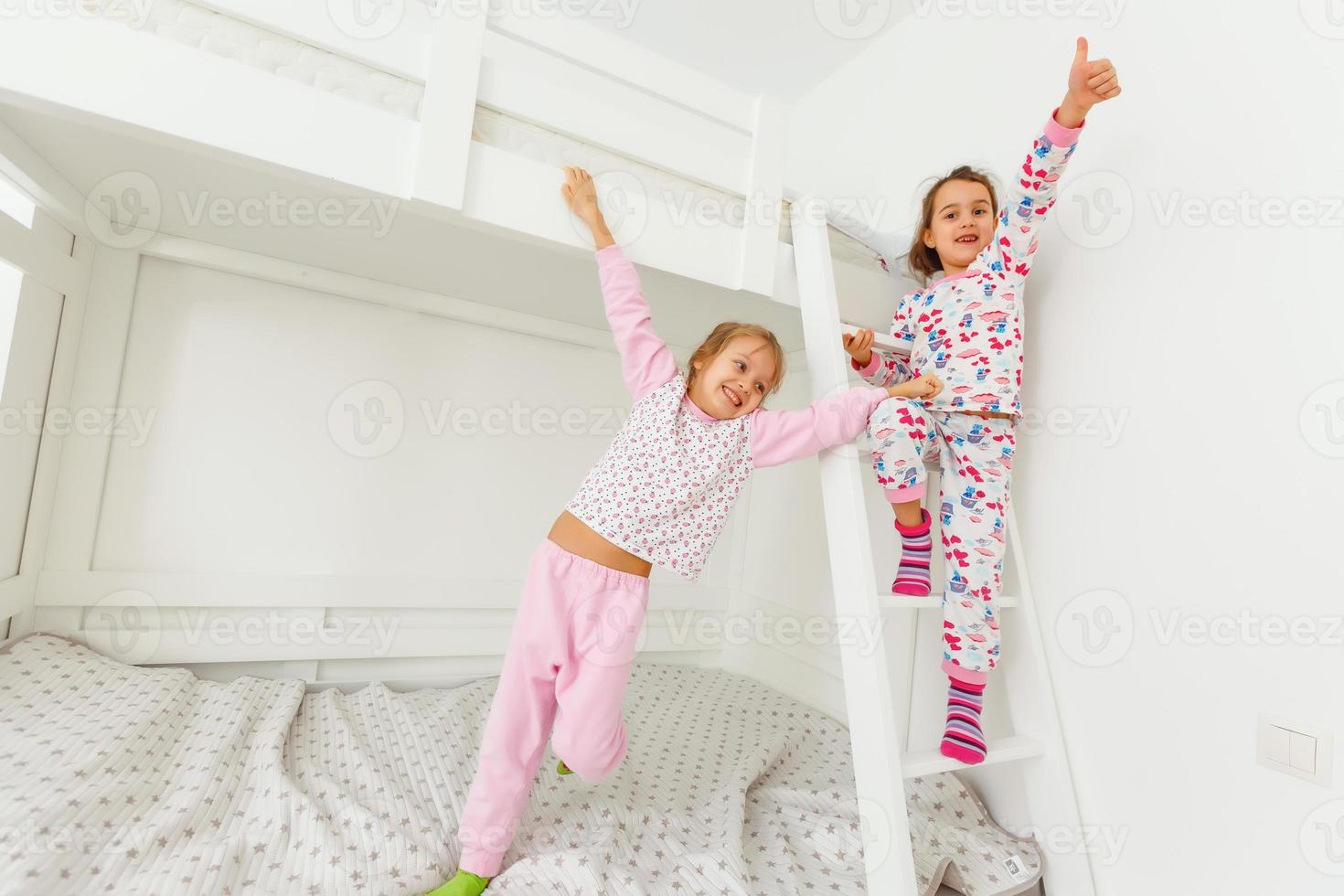 Children in soft warm pajamas playing in bed photo