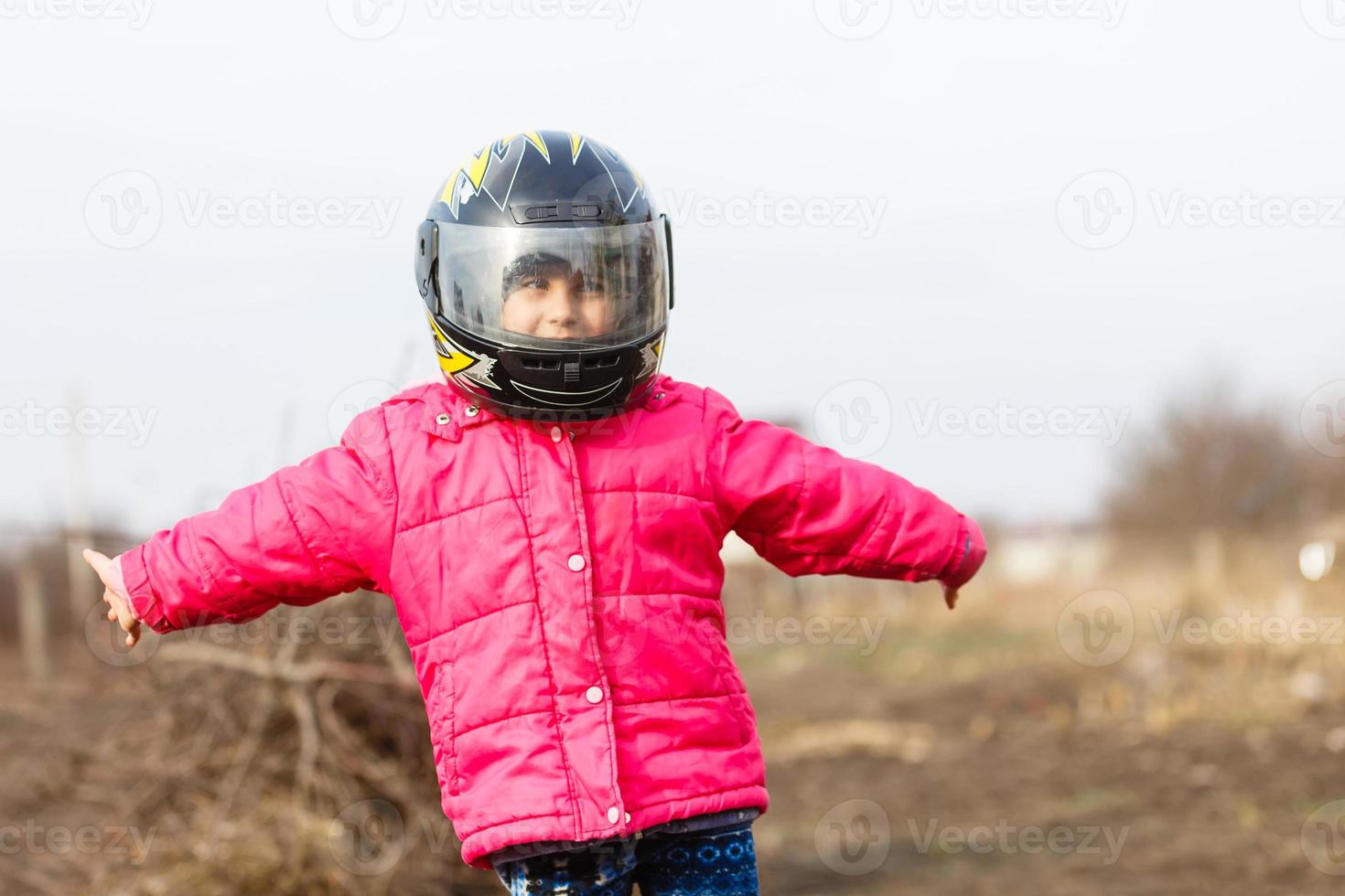 portrait of a little girl smiling in a protective helmet female child in motocross moto helmet. biker girl in motocross helmet photo