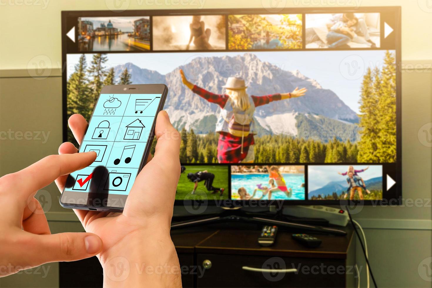 Man watching TV in living room with remote in the hand photo